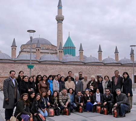 A group of people posing for a photo with an architectural monument in the background