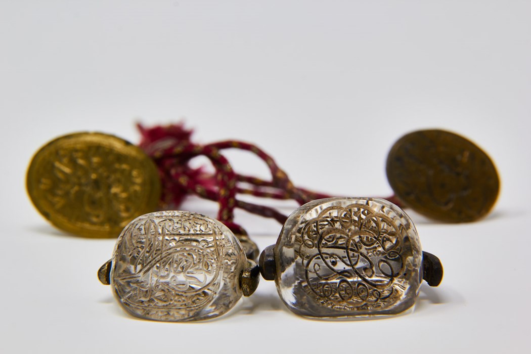 Some threaded coin shaped artefacts with Arabic text written on them